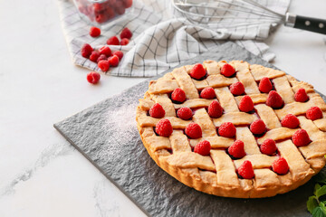 Tasty raspberry pie and ingredients on table