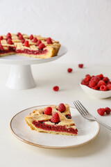 Piece of yummy raspberry pie on light background