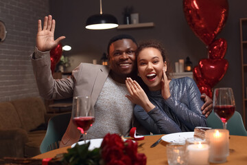 Happy engaged African-American couple on Valentine's Day at home