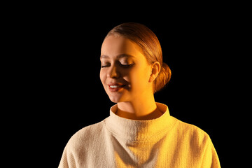 Toned portrait of beautiful young woman on dark background