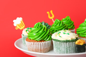 Stand with tasty cupcakes for St. Patrick's Day on color background