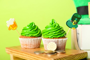 Tasty cupcakes for St. Patrick's Day on color background