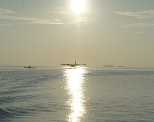 Obraz premium sea plane on calm ocean at sunset
