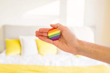 Obraz na płótnie Canvas Woman with rainbow flag on bed. Lesbian celebrating pride month during Covid-19 Coronavirus pandemic quarantine, stay at home, social distancing and self isolation concept