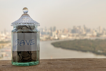 The pile of coins in glass bottle on cityscape background for concept for growth and saving money....