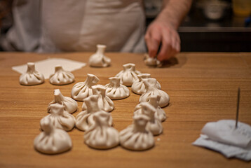 cook raw khinkali on a wooden table, horizontal