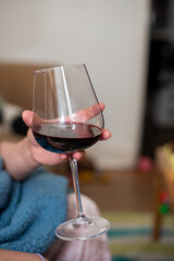 Close up shot on person holding glass of red wine