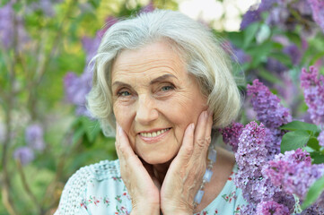 happy  senior beautiful woman on  lilacs background