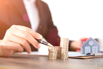 Real estate practitioners stack coins and tables on the small house model and related documents