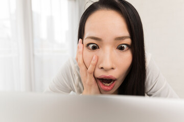 女性はノートパソコンを見て驚いている。