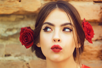 Curious woman with red lips and fresh roses in hair