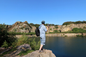 Fototapeta premium hiker on the rocky shores of Lake Opalsoen on Bornholm