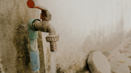 The faucet is attached to the old brick wall.