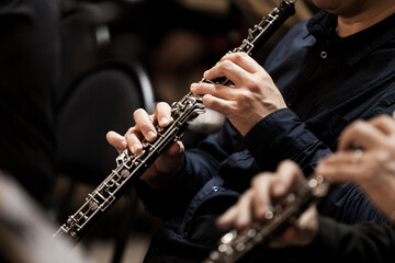  Hands of a musician playing the oboe in an orchestra  - obrazy, fototapety, plakaty
