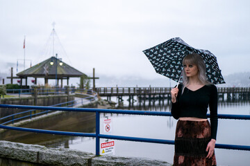 傘をさして海を眺める白人女性