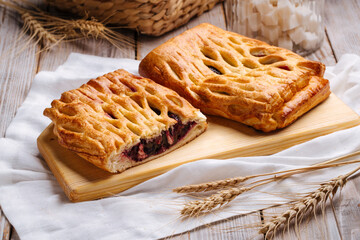 Side view on fresh baked berry jam pie on the wooden cutting board