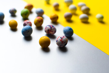 Bright colored eggs on a gray.yellow background. Easter theme, holiday. Happy easter card with copy space for text in minimalist easter style. Color of the year 2021. Bright yellow and extremely gray.