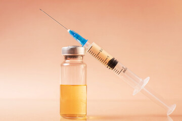 syringe, ampoule on a beige background, vaccination concept..