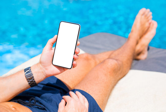 Man using mobile phone while relaxing by the pool