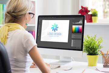 Graphic designer creating company's logo on desktop computer - obrazy, fototapety, plakaty