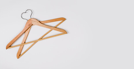 Clothes hangers made of wood on a light background. Hangers made of environmentally friendly material. Space for text
