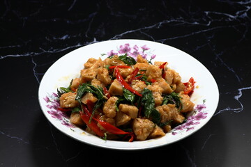 Traditional fried and stirred spicy chopped shrimp ball mixed with chilly and basil serving on the plate. 