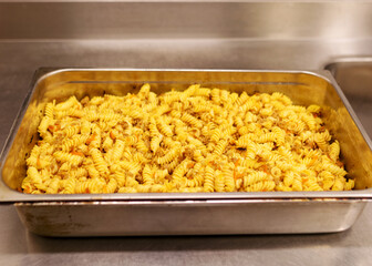 boiled pasta with meat and toppings in a metal pan, cooking