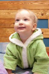 one Smiling little child wearing green bathrobe