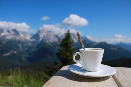 Primo piano di una tazzina da caffé con dietro una bellissima vista sulle montagne dal rifugio 5 laghi in Trentino, viaggi e paesaggi in Italia