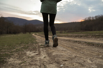 Woman tourist hiker walks along the village road