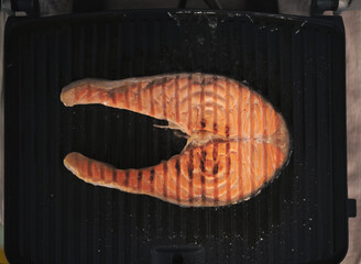 cooking red fish in a pan. healthy sea food full of omega fat.