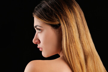 Profilo di donna con spalla nuda su sfondo nero