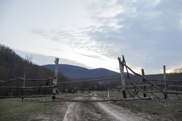 Rustic wooden gate with sunset sky background