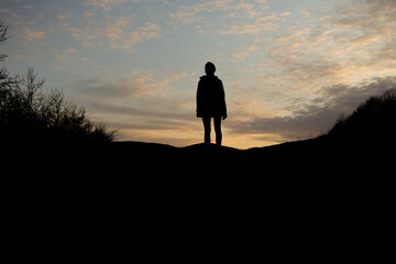 Girl silhouette with sunset sky background