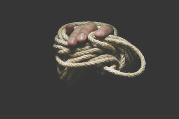 hand trying to free itself from a rope that is tightening it, concept of freedom