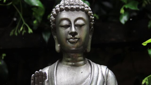 Metal Buddha Statue Lotus Pose in the Garden. 4K Resolution.