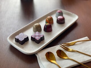 Cute Chocolate on white dish with gold spoon in many special shape of chocolate for Valentine