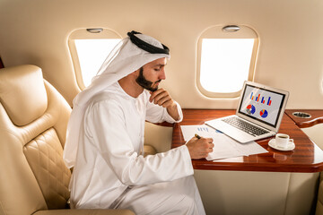 Arabian man wearing kandora flying on private jet