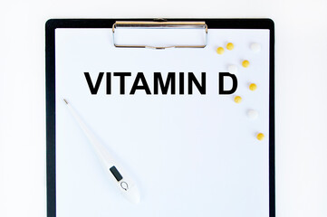 On the tablet for writing the text vitamin D, next to the thermometer and yellow tablets.