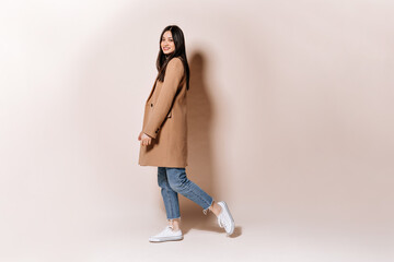 Full-length shot of girl in stylish coat and jeans