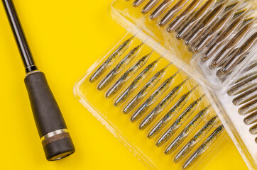 Rubber baits for fishing for predatory fish transparent packaging and fishing rod on a yellow background.