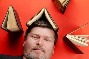 The head of a middle-aged man with gray hair lies among open books. The benefits of reading books...