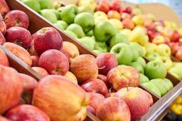 Multicolored apples in wooden boxes on store shelves