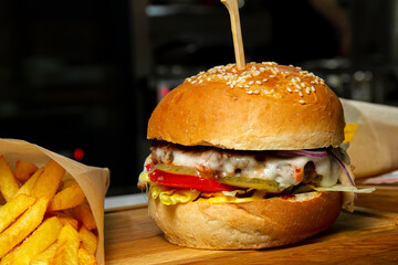 Fast food hamburger and french fries on a wooden plate