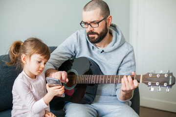 Little girl showing her father a song on a phone
