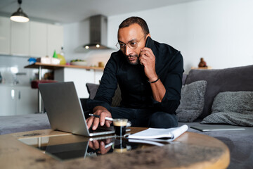 Handsome entrepreneur managing accounts at home