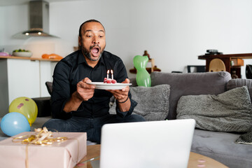 Handsome 40 years old man blowing candles on his birthday cake
