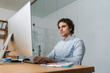 Confident young busy entrepreneur sitting at the office desk