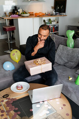 Mature man chatting with his family through internet during his birthday