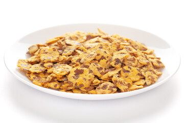Spicy Chana Jor Garam in a white ceramic plate, made with air-fried Bengal Chickpea. Pile of Indian spicy snacks (Namkeen), under backlight, side view, 
